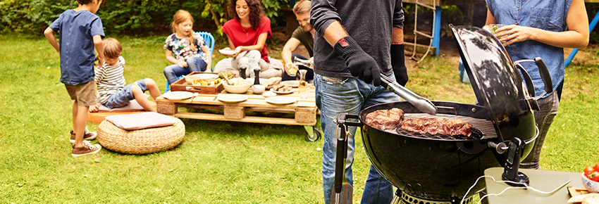 Mann grillt mit Holzkohlegrill