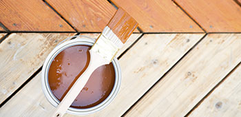 Holzterasse mit Holzfarbe und Pinsel