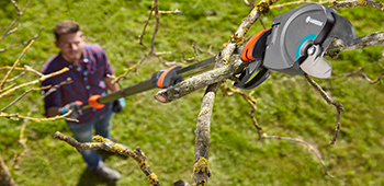Mann arbeitet mit einem Elektro-Teleskop-Hochentaster.