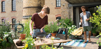 Frau arbeitet in ihrem Garten, der sich in der Stadt befindet.