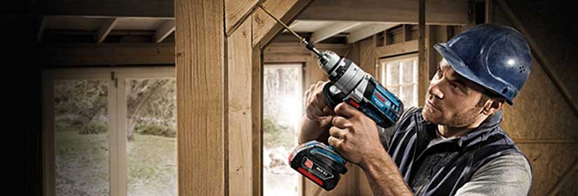 Mann arbeitet mit einem Akkubohrschrauber von der Marke Bosch.