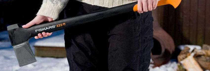 Frau h&auml;lt eine Axt von der Marke Fiskars.