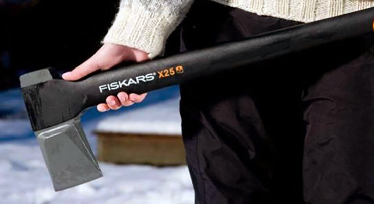Frau hält eine Axt von der Marke Fiskars.