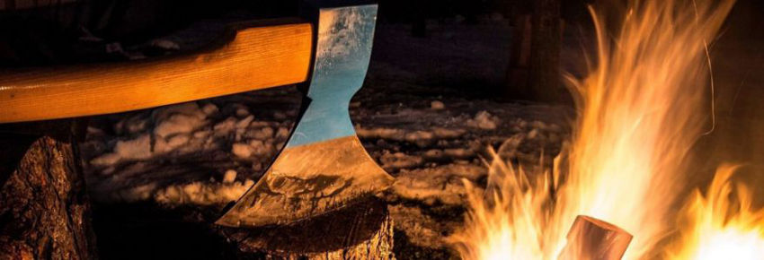 Axt auf Holz bei Feuer.