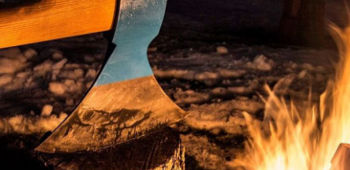 Axt auf Holz bei Feuer.