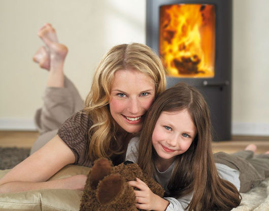Mutter und Tochter liegen vor dem Kamin.