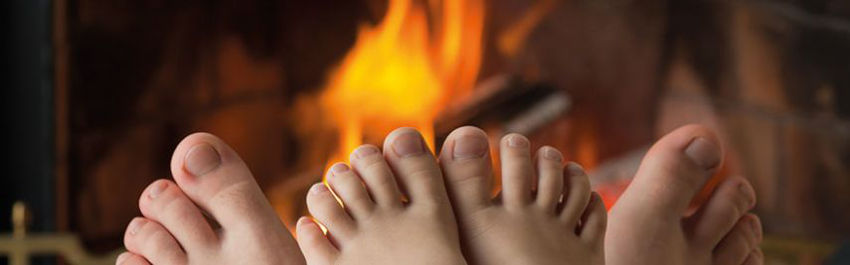Füße vor Kamin.