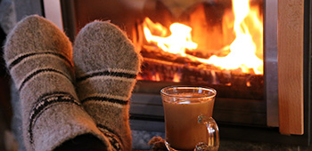 F&uuml;&szlig;e mit Socken vor einem Kaminofen.