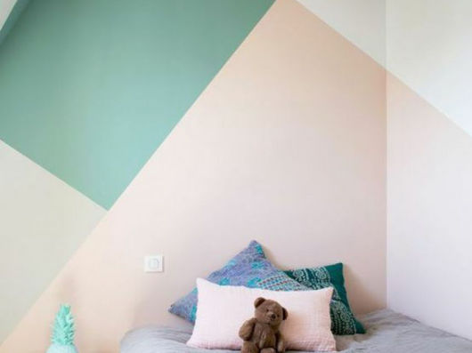 Wand mit Muster in den Farben Grün, Lachs und Gelb.