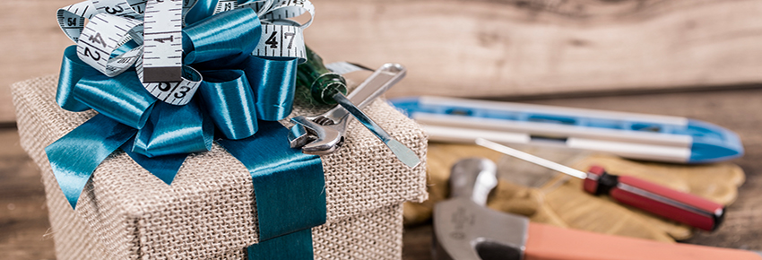 Weihnachtsgeschenk im Vordergrund, Hintergrund: Schraubenzieher und Hammer