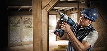 Mann arbeitet mit einem Akkubohrer von der Marke Bosch.