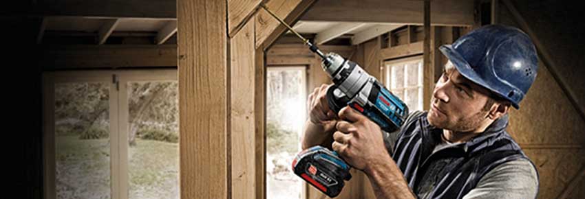 Mann arbeitet mit einem Akkubohrer von der Marke Bosch.
