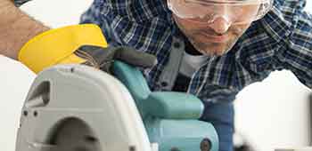 Mann arbeitet mit einer Handkreiss&auml;ge der Marke Makita.