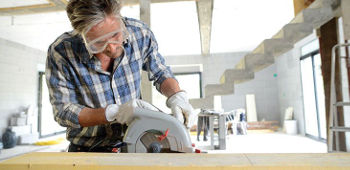 Mann arbeitet mit einer Handkreiss&auml;ge.