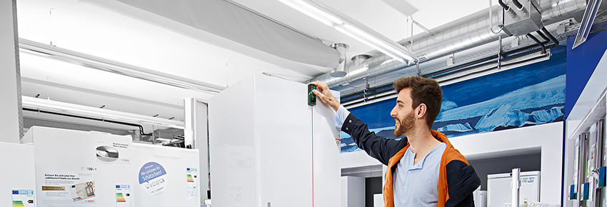 Mann arbeitet mit einem Laser Entfernungsmesser.