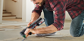 Mann arbeitet mit dem Multifunktionswerk der Marke Bosch